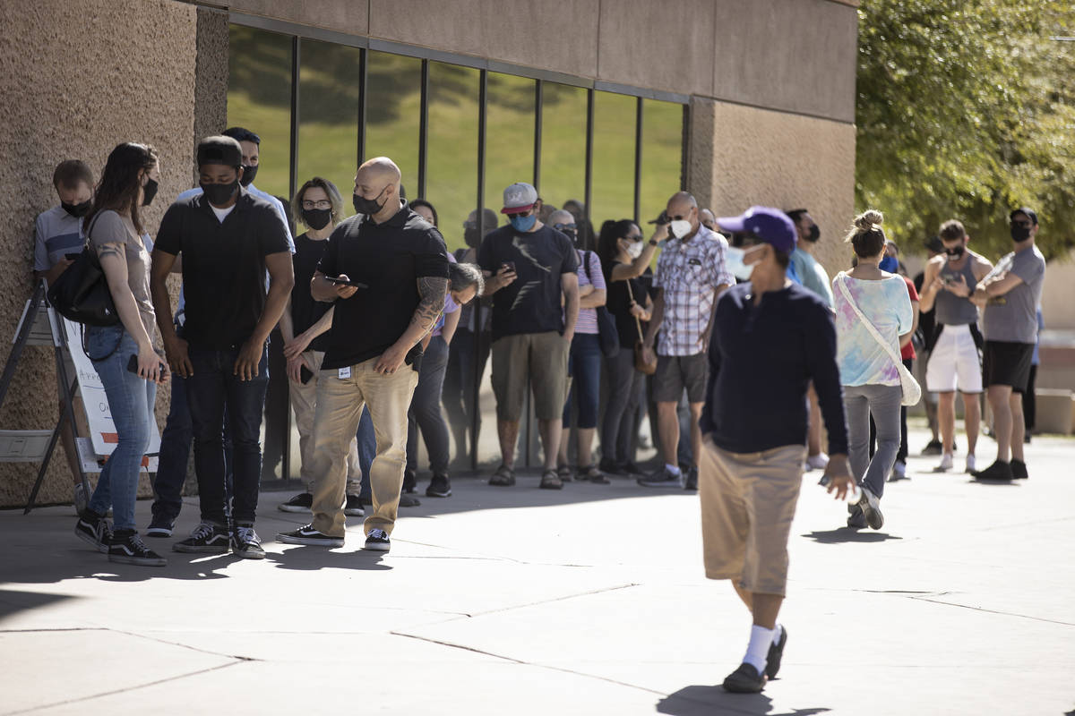 People wait in line to receive the COVID-19 vaccine at the Cashman Center in Las Vegas, Tuesday ...