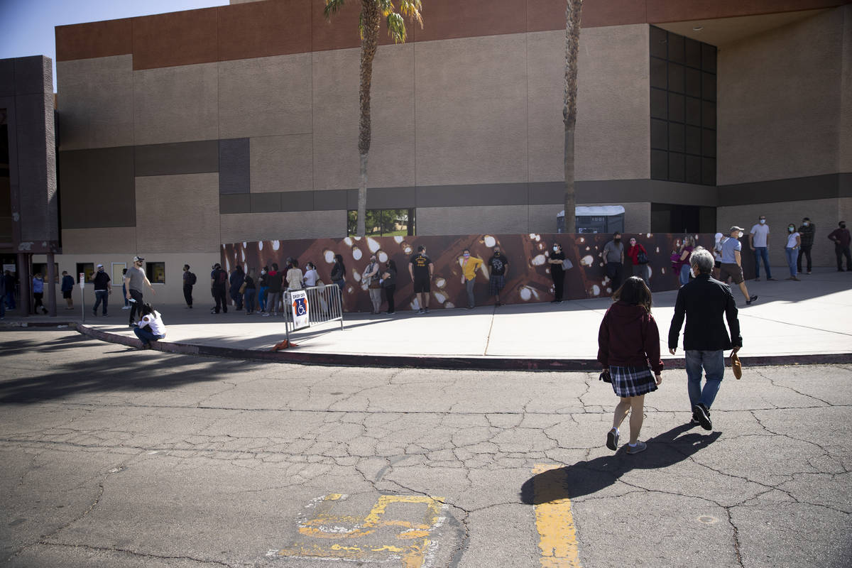 People wait in line to receive the COVID-19 vaccine at the Cashman Center in Las Vegas, Tuesday ...