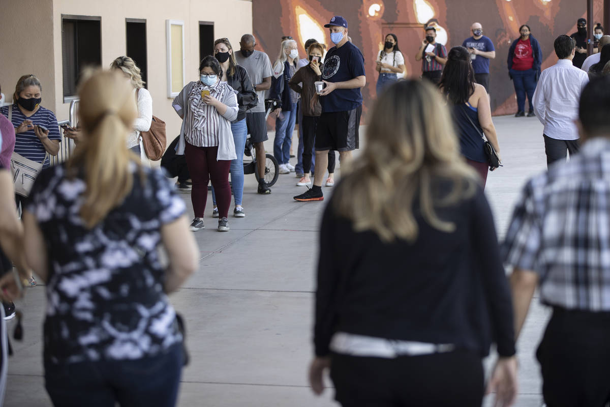 People wait in line to receive the COVID-19 vaccine at the Cashman Center in Las Vegas, Tuesday ...