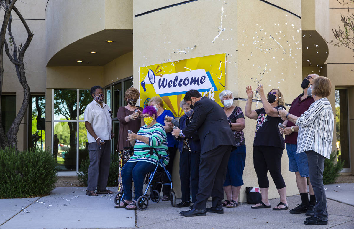 Clark County Commissioner Michael Naft, center, helps a senior as they use streamers and confet ...