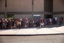 People wait in line to receive the COVID-19 vaccine at the Cashman Center in Las Vegas, April 6 ...