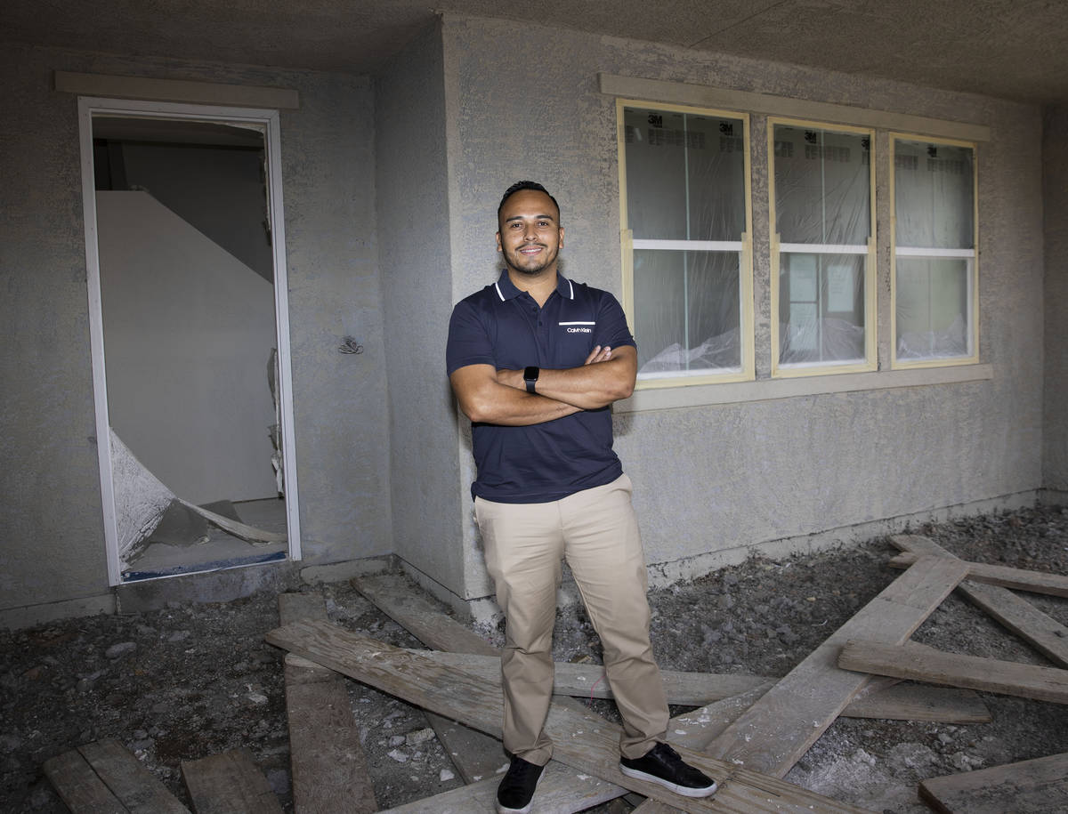Gustavo Lopez, a realtor at Scofield Realty, poses for a photo in front of a new housing commun ...