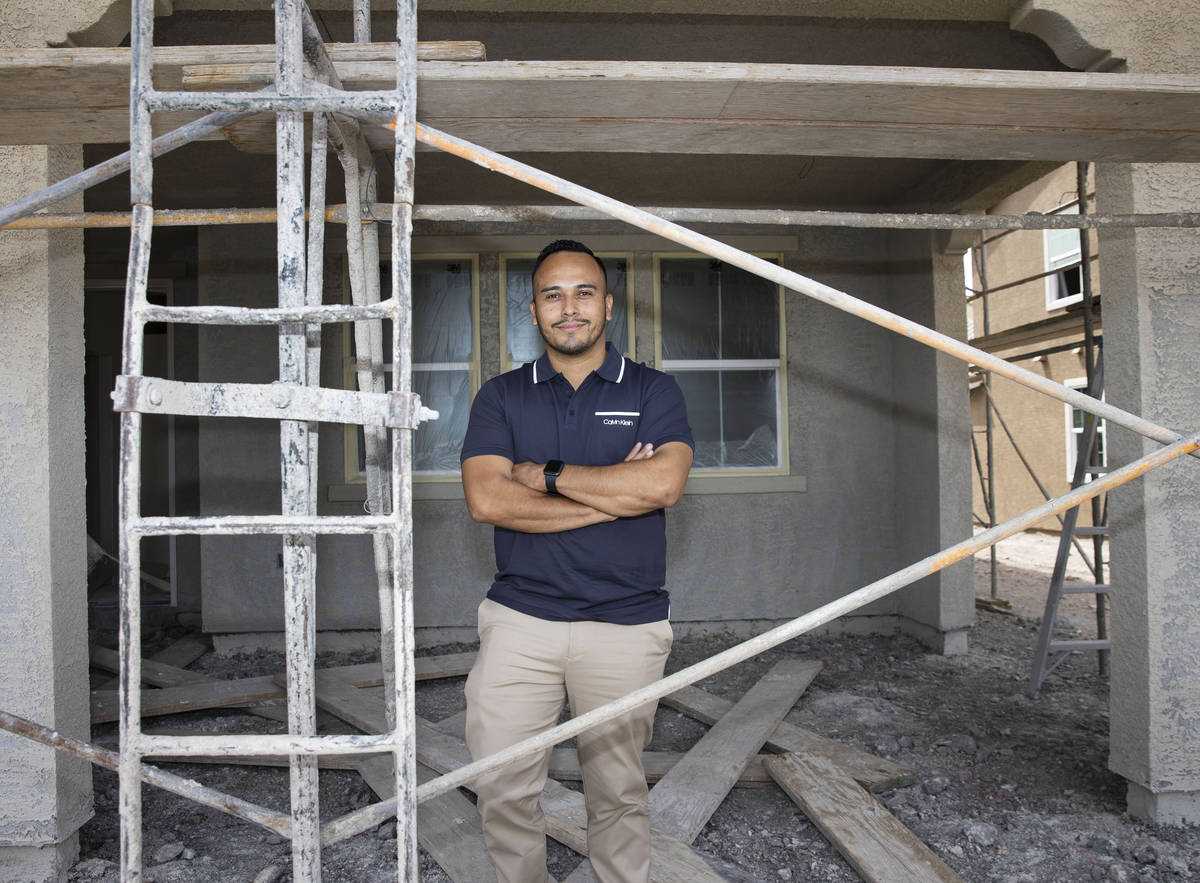 Gustavo Lopez, a realtor at Scofield Realty, poses for a photo in front of a new housing commun ...