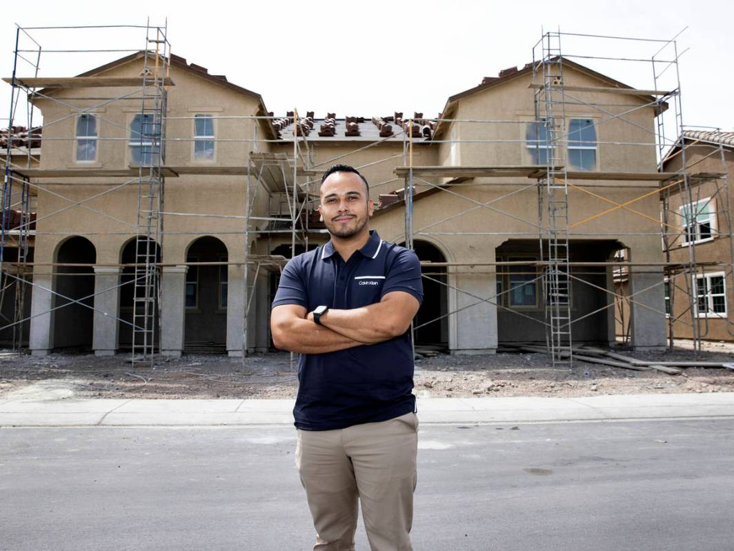 Gustavo Lopez, a realtor at Scofield Realty, poses for a photo in front of a new housing commun ...