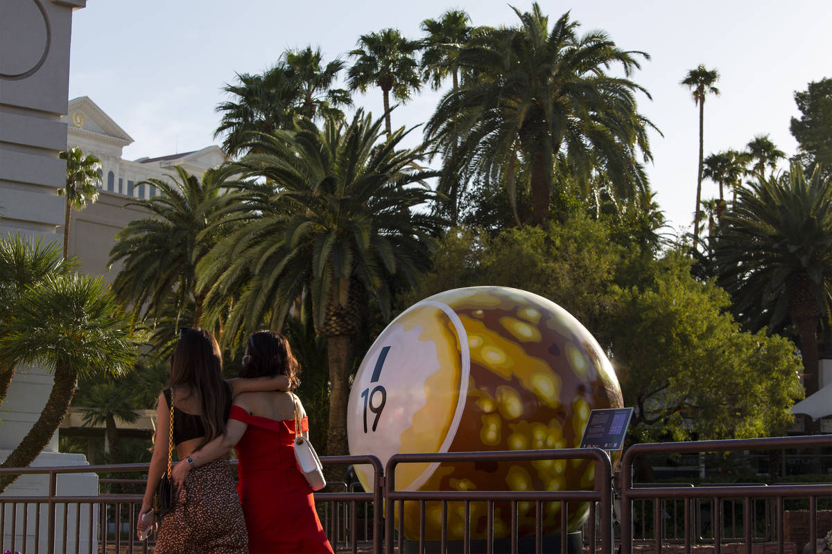Pedestrians pass a 200-pound bingo ball by artist Jerry Misko, displayed in front of The Mirage ...