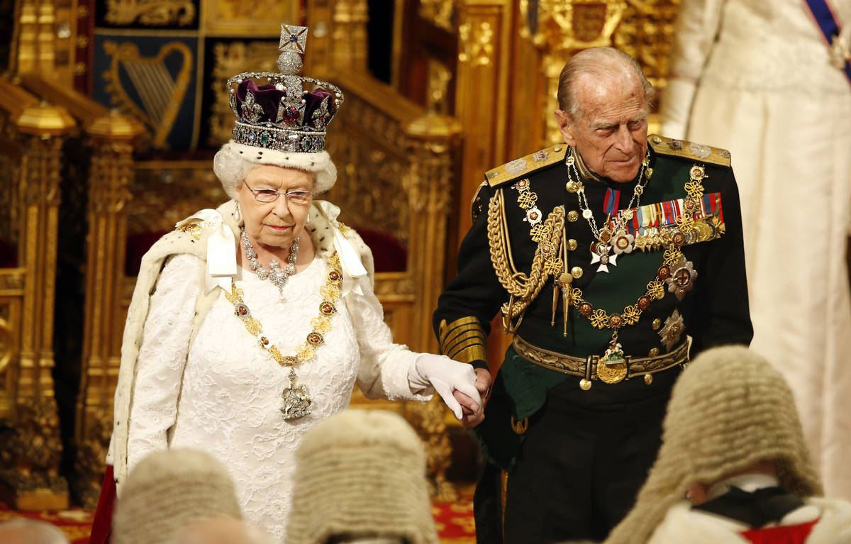 Britain's Queen Elizabeth, accompanied by Prince Philip, looks at the assembled lawmakers after ...