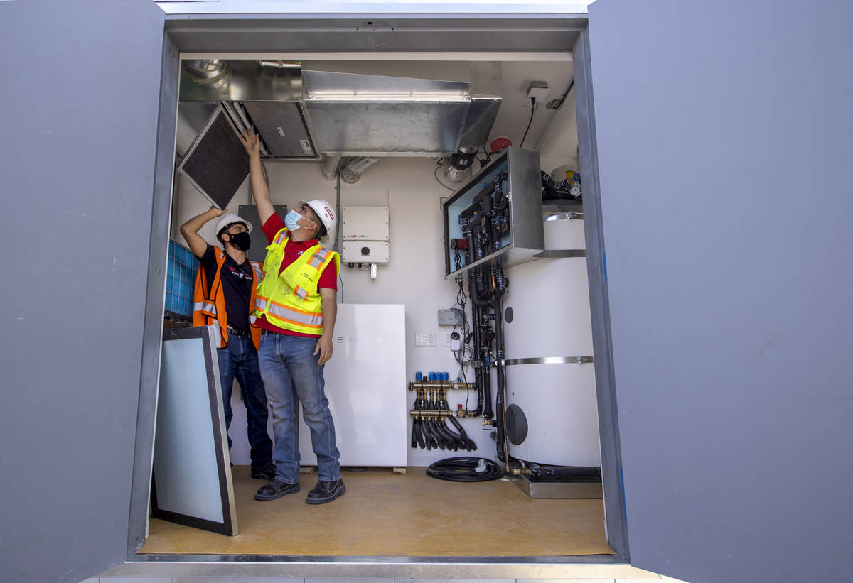 Students Alejandro Munoz, right, and Miguel Vazquez look at the ventilation system as a UNLV te ...