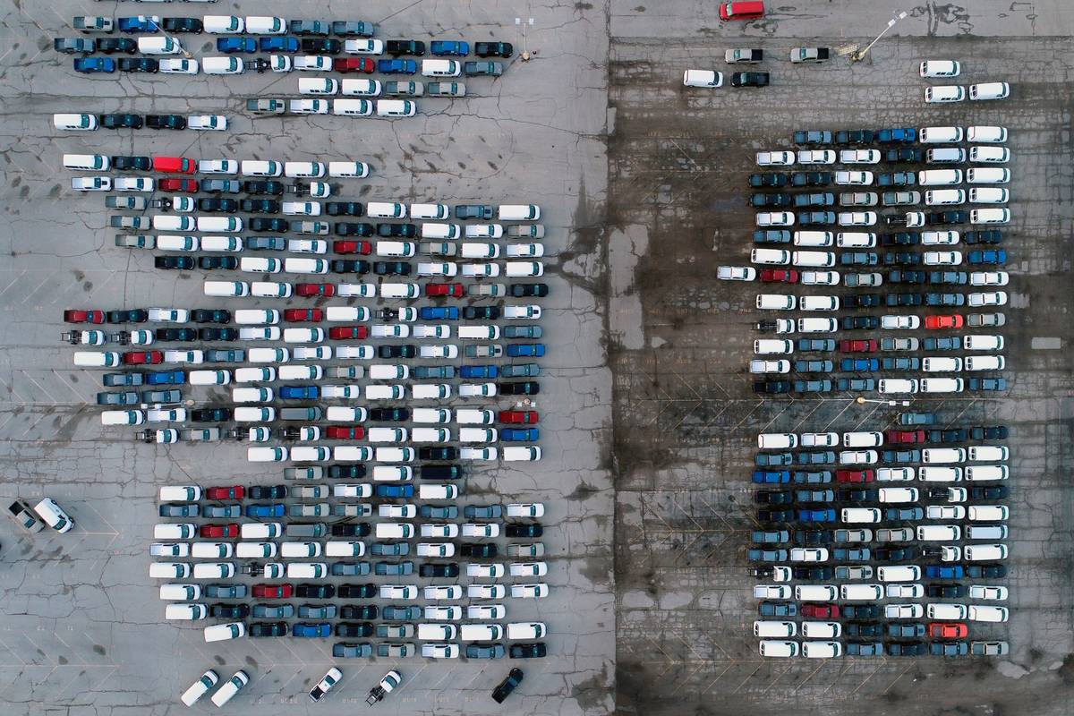 Mid-sized pickup trucks and full-size vans are seen in a parking lot outside a General Motors a ...