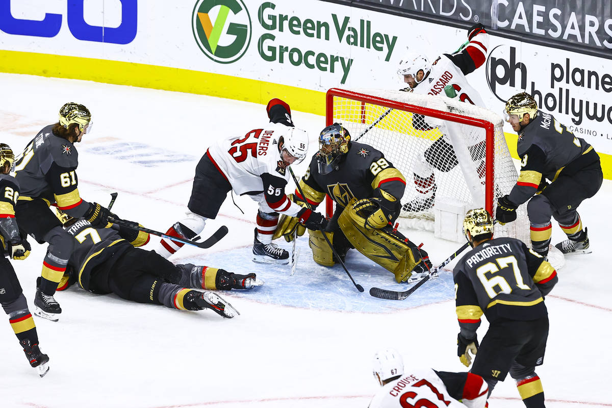 Golden Knights goaltender Marc-Andre Fleury (29) defends the net in front of Arizona Coyotes' J ...