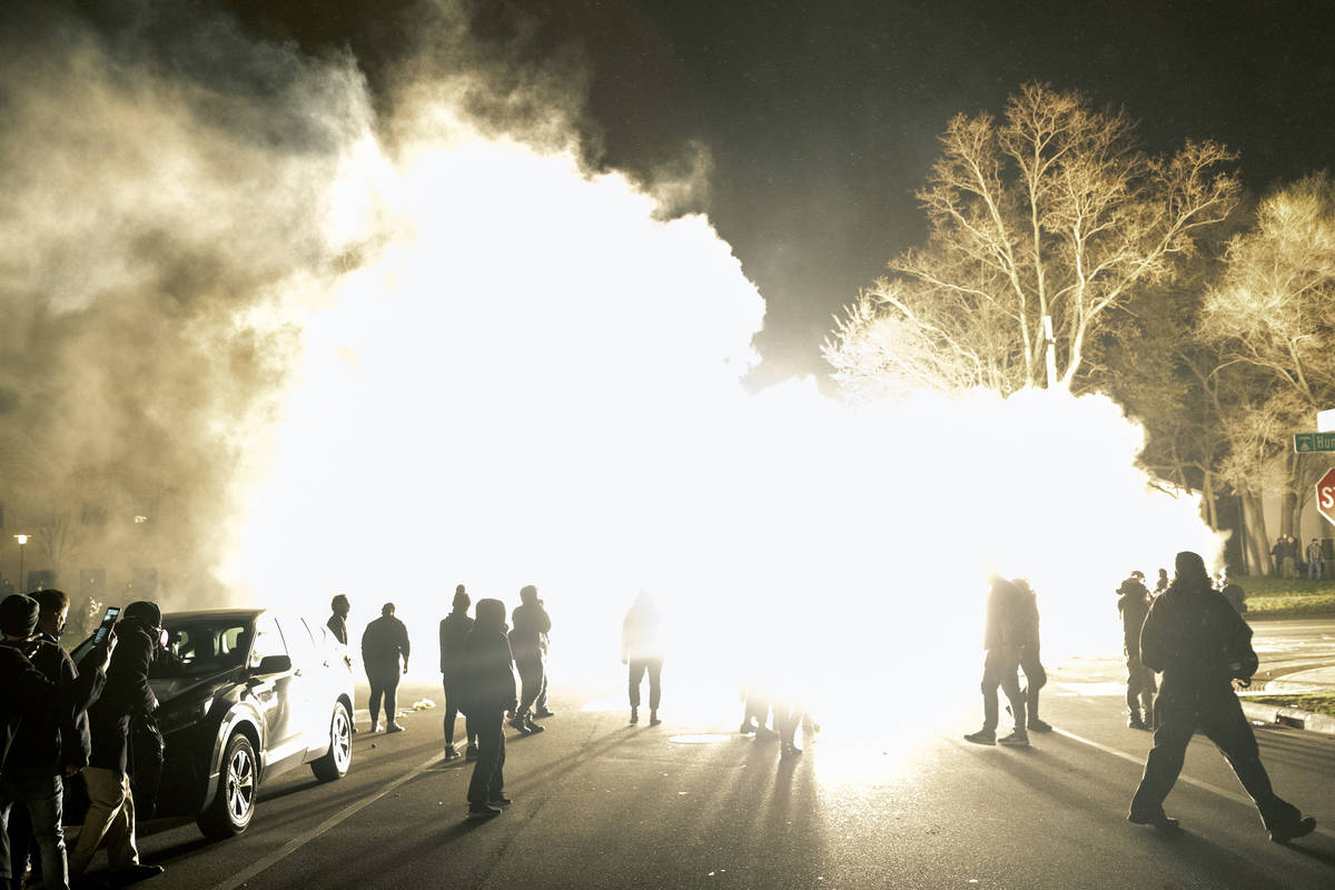 Flash bombs are used by authorities to disperse a crowd gathered in protest at the Brooklyn Cen ...