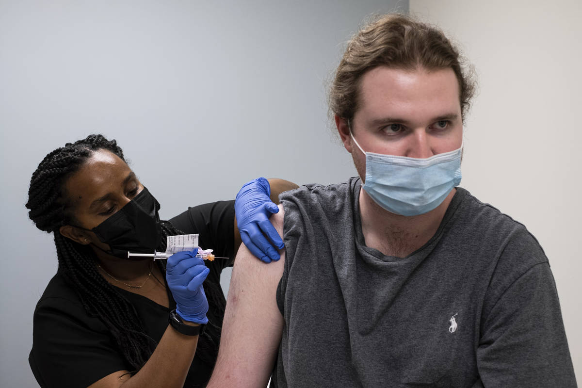 Cole Smith receives a Moderna variant vaccine shot from clinical research nurse Tigisty Girmay ...