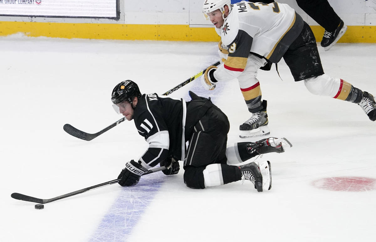 Los Angeles Kings center Anze Kopitar, left, trips while under pressure from Vegas Golden Knigh ...