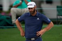 Dustin Johnson looks down after putting on the 18th hole during the second round of the Masters ...