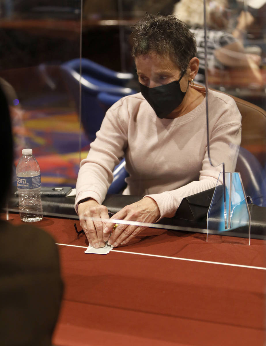Jan Fisher of Las Vegas, co-host of 2021 Nevada State Ladies Poker Championship, checks cards d ...