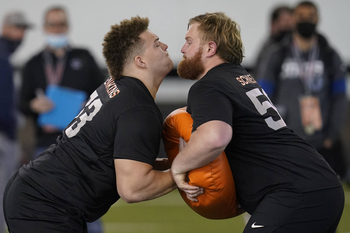 Oklahoma State offensive linemen Teven Jenkins, left, and Ry Schneider, right, participate in a ...