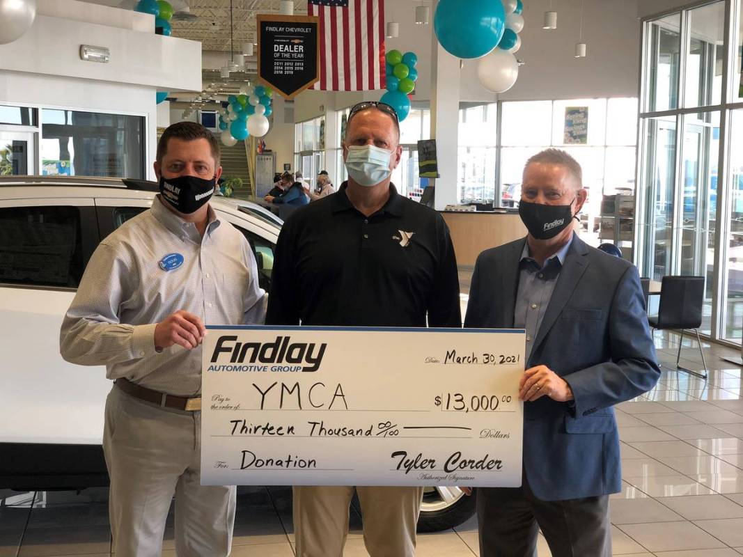 Mike Lubbe, center, president/CEO of YMCA Southern Nevada, accepts a donation check from Doug F ...