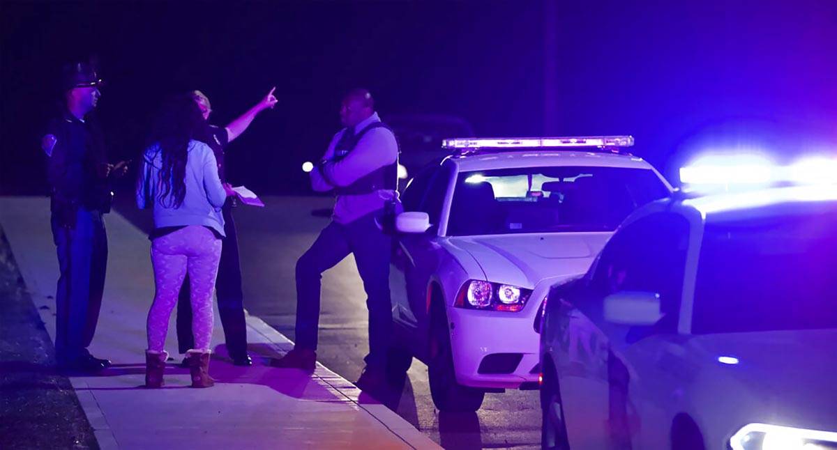 A woman asks law enforcement near the FedEx hub following a shooting in Indianapolis, IN., Frid ...