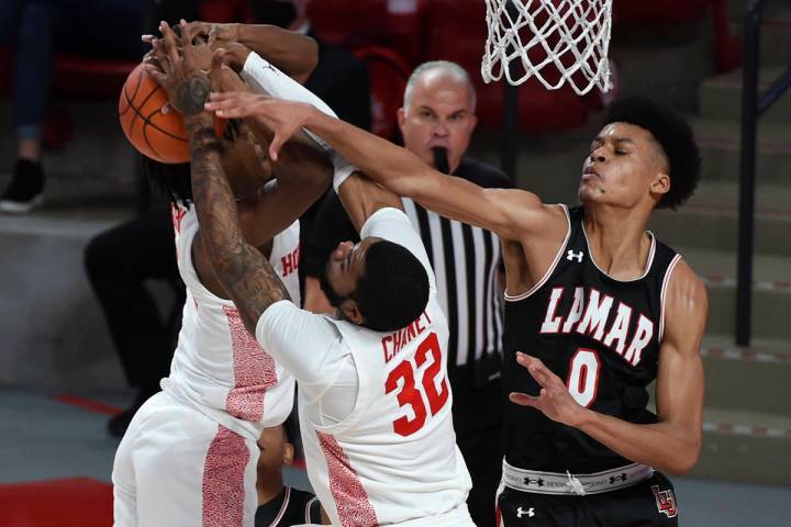 Lamar center David Muoka (0), Houston forward Reggie Chaney (32), and guard Tramon Mark, left, ...