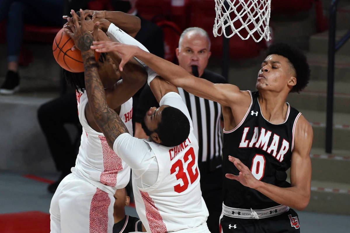 Lamar center David Muoka (0), Houston forward Reggie Chaney (32), and guard Tramon Mark, left, ...