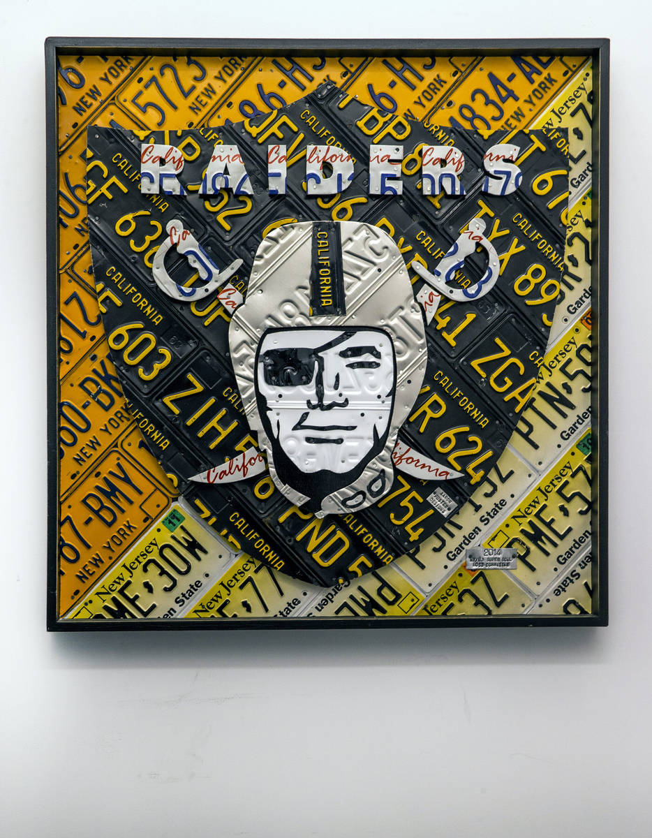 A Raiders logo art piece constructed of license plates hangs in a hallway during a tour of the ...