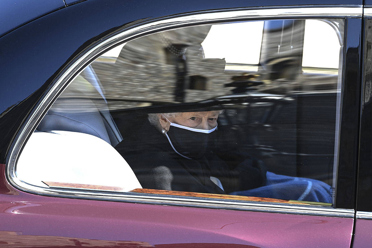 Britain's Queen Elizabeth II follows the coffin in a car as it makes it's way past the Round To ...