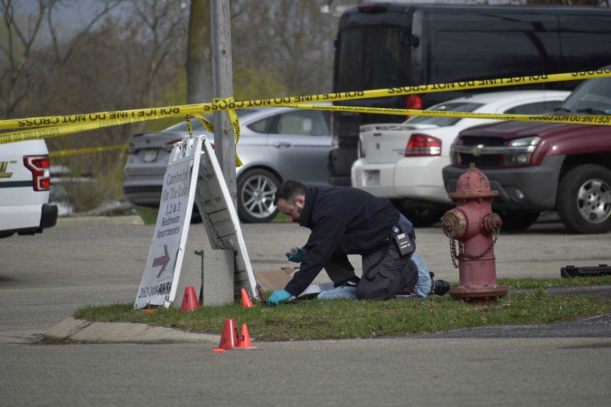An investigator looks for evidence outside the Somers House Tavern in Somers, Wis., just outsid ...