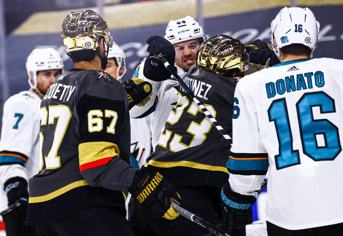 Golden Knights' Alec Martinez (23) fights San Jose Sharks' Marc-Edouard Vlasic (44) during the ...