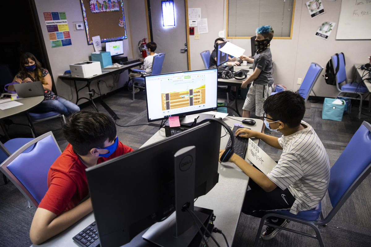 Fifth-graders Michael Bean, left, and Aaron Falcon, both 11, work on math studies during a clas ...