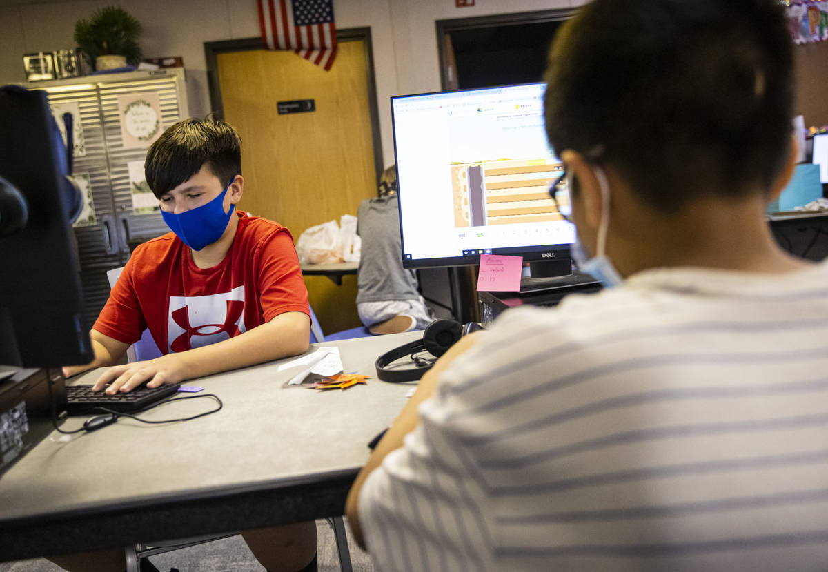 Fifth-graders Michael Bean, left, and Aaron Falcon, both 11, work on math studies during a clas ...