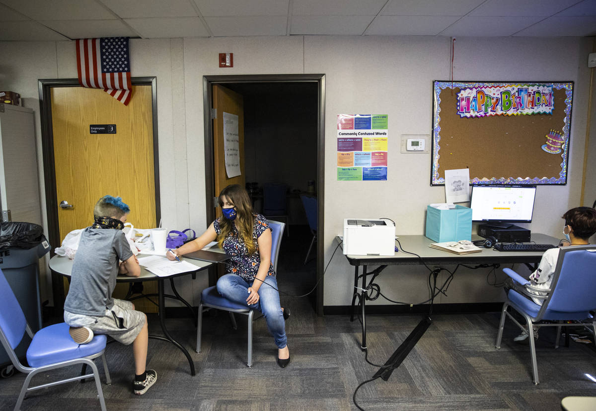 Ashley Campbell, chief of staff at Nevada Action, second from left, helps fifth-grader Jack Gri ...