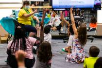Students raise their hands as learning guide Tammy Slank, left, leads a discussion during a thi ...