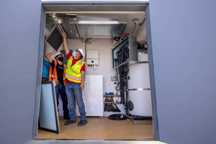 Students Alejandro Munoz, right, and Miguel Vazquez look at the ventilation system as a UNLV te ...