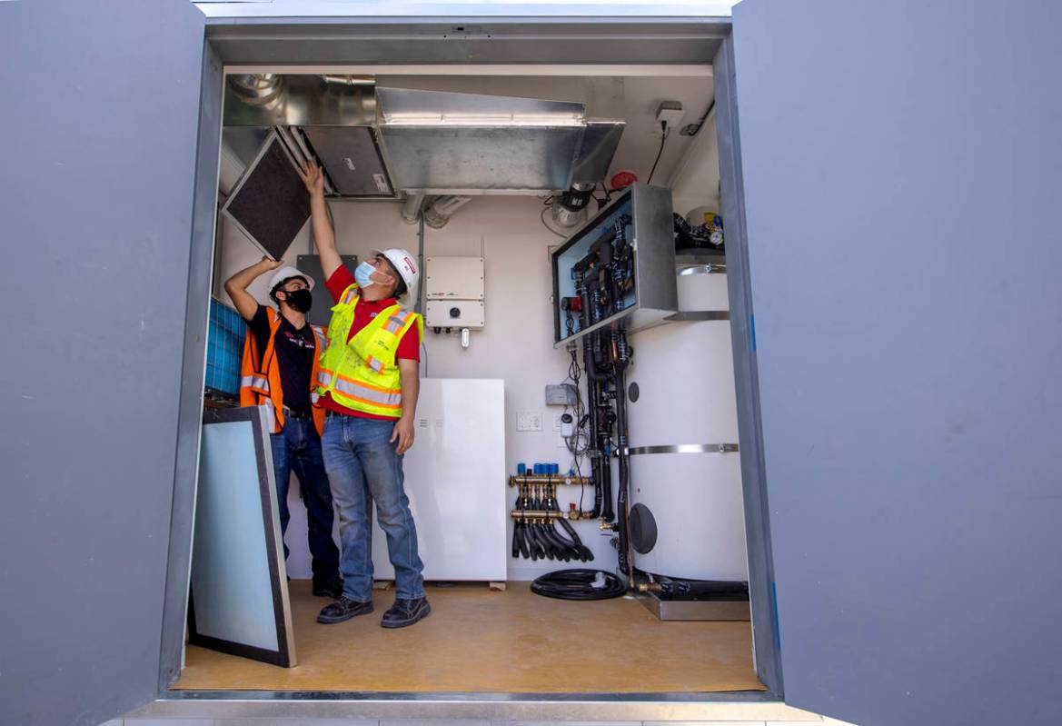 Students Alejandro Munoz, right, and Miguel Vazquez look at the ventilation system as a UNLV te ...