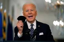 In this March 11, 2021, file photo, President Joe Biden holds up his face mask as he speaks abo ...