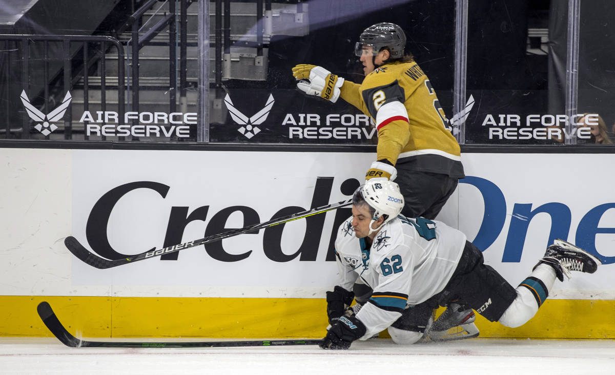 Golden Knights defenseman Zach Whitecloud (2) sends the puck on as San Jose Sharks right wing K ...