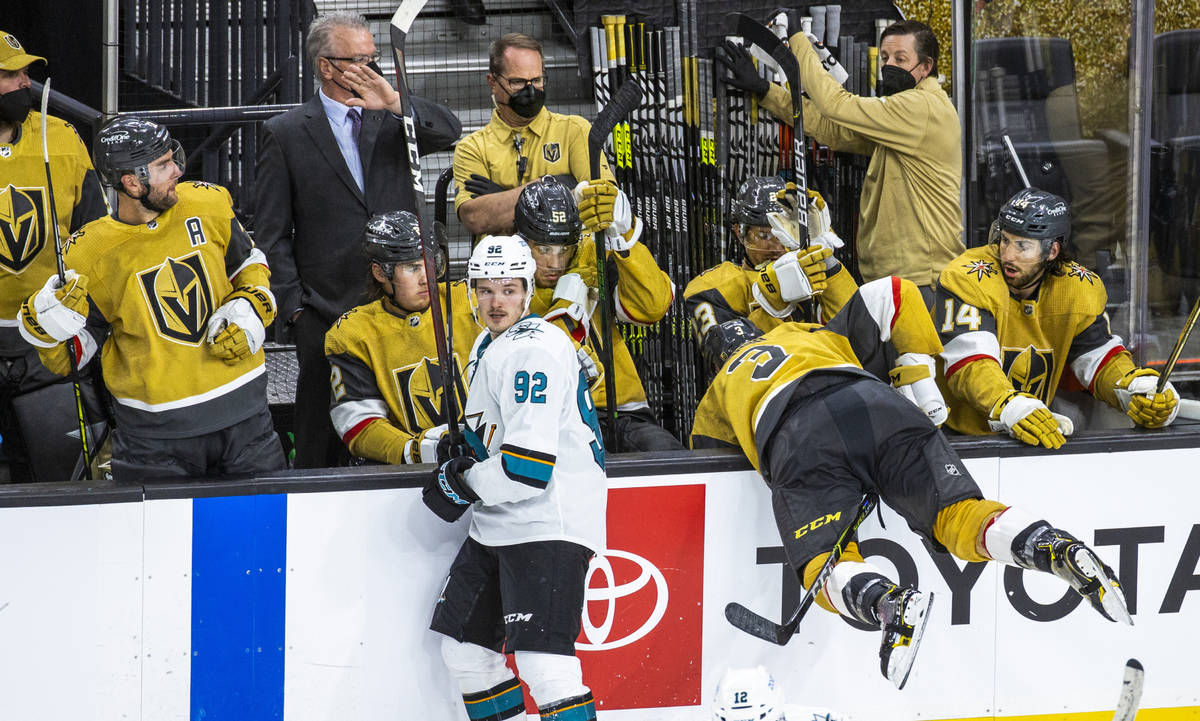 Teammates react and take cover as Golden Knights defenseman Peter DiLiberatore (3) goes over th ...