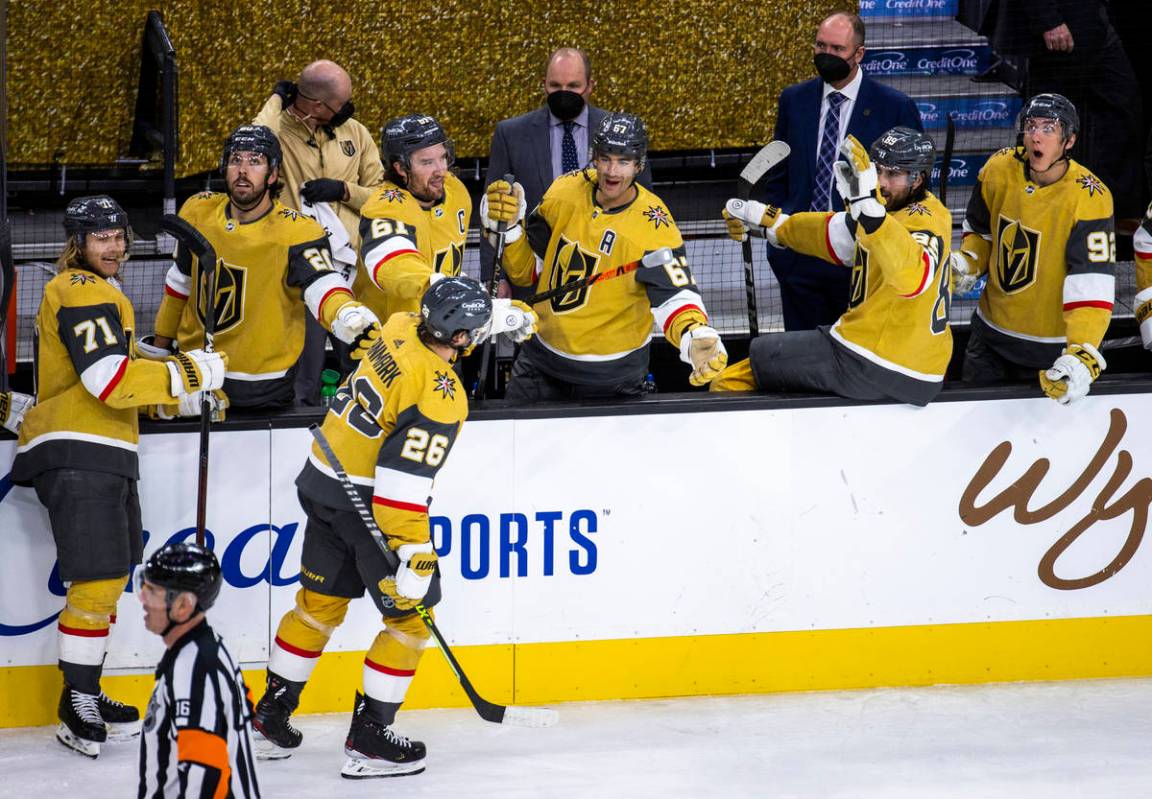 Golden Knights center Mattias Janmark (26) is cheered on by teammates after scoring his first g ...