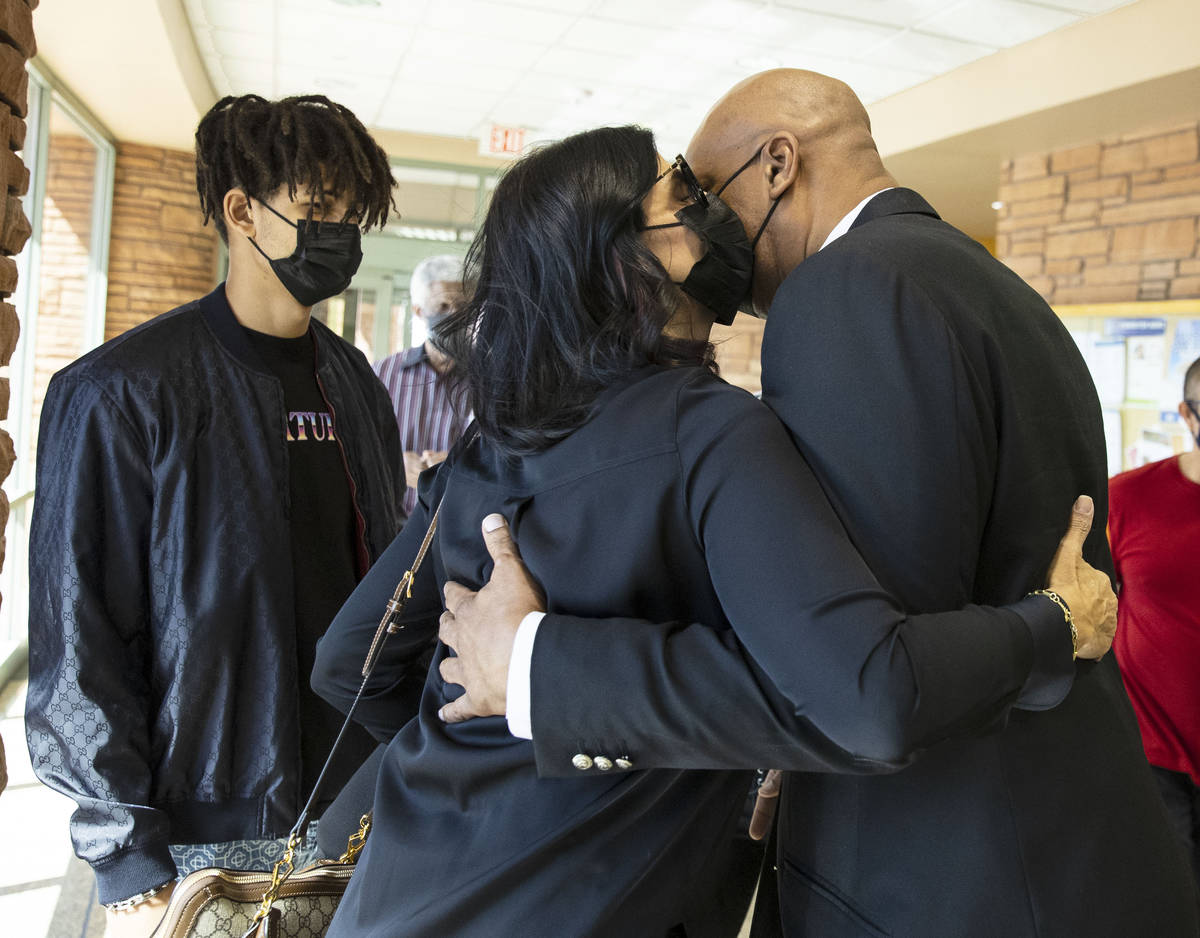 Former NBA player Jackie Robinson embraced by his wife Maria as their son J.J. looks on after t ...