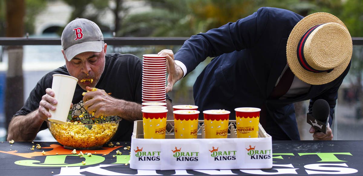Geoff Esper, left, competes in the World Popcorn Eating Championship as emcee George Shea, righ ...