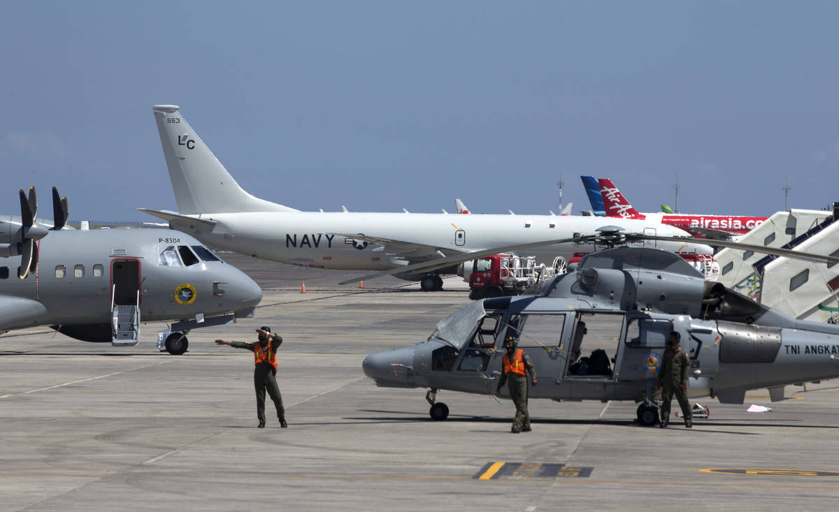 The U.S. Navy P-8 Poseidon aircraft, rear, is parked on a tarmac at at Ngurah Rai Military Air ...