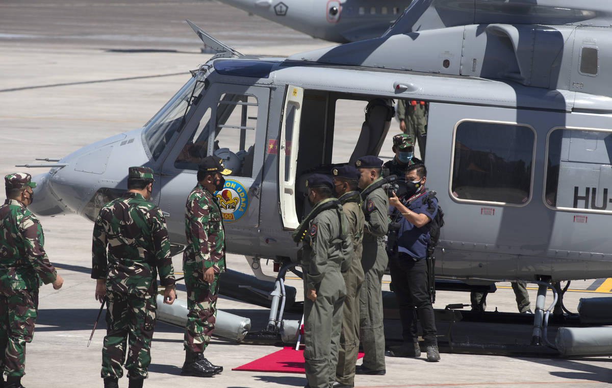 Indonesian Military chief Hadi Tjahjanto, third from left, boards a helicopter for a search mis ...