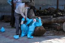 A relative of a person who died of COVID-19 breaks down during cremation in Jammu, India, Sunda ...