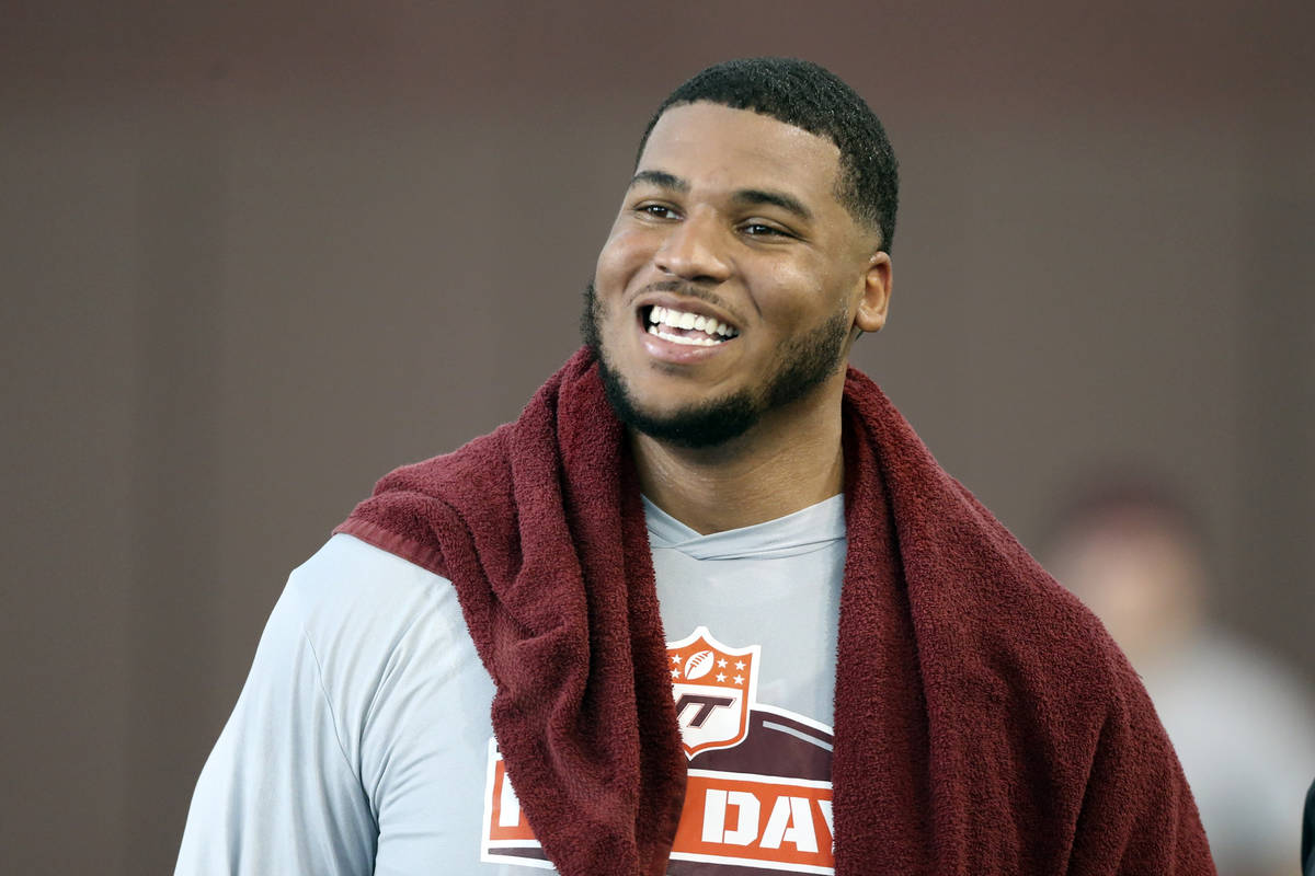 Christian Darrisaw smiles after completing a set of offensive line drills during Virginia Tech ...