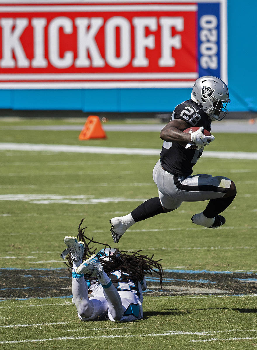 Raiders running back Josh Jacobs leaps over Carolina Panthers safety Tre Boston (33) in the thi ...