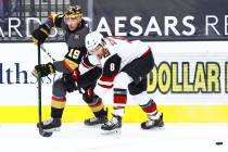 Golden Knights' Reilly Smith (19) passes the puck under pressure from Arizona Coyotes' Nick Sch ...