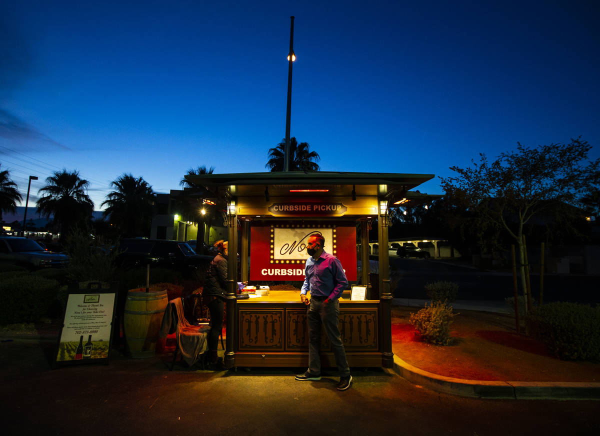 Marcello Mauro, co-owner of Nora's Italian Cuisine, checks on the curbside pickup area on Jan. ...