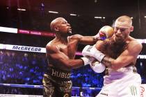Floyd Mayweather Jr. lands a punch against Conor McGregor in the blank round on Saturday, Aug 2 ...