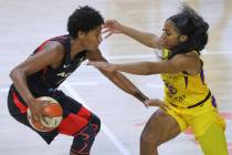 Las Vegas Aces' Angel McCoughtry, left, drives against Los Angeles Sparks' Te'a Cooper during t ...