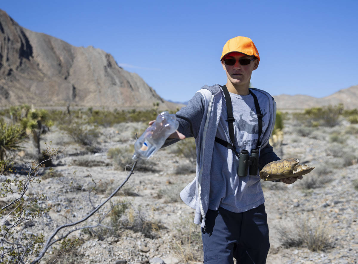 Christian Daniels, 15, holding a tortoise shell, retrieves a plastic bottle on Saturday, April ...