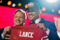 North Dakota State quarterback Trey Lance, right, holds a jersey with NFL Commissioner Roger Go ...
